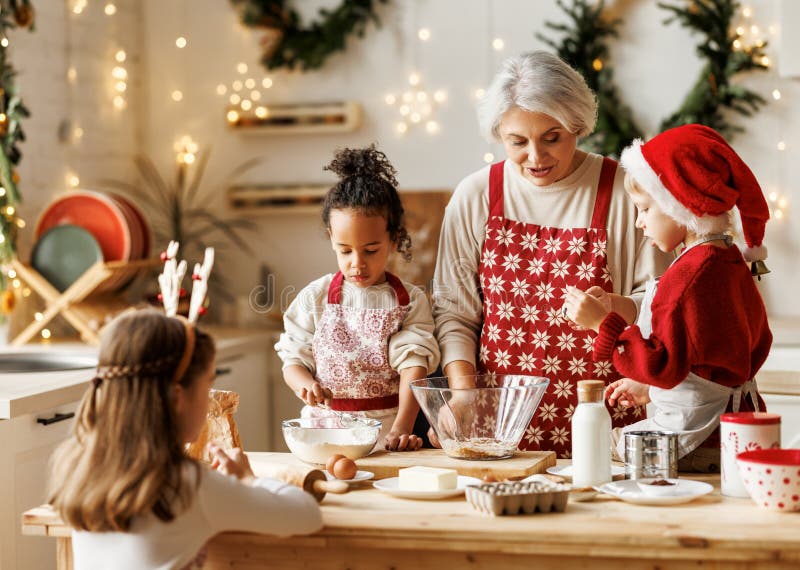 Avó de família multiétnica e três filhos cozinhando biscoitos de natal juntos na cozinha foto de stock royalty free