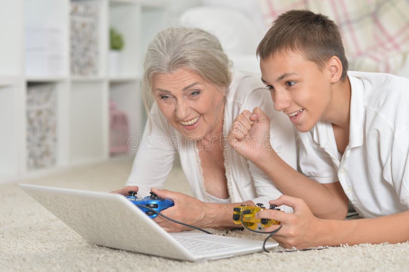 Avó e neto jogando jogos de computador com laptop imagens de stock royalty free