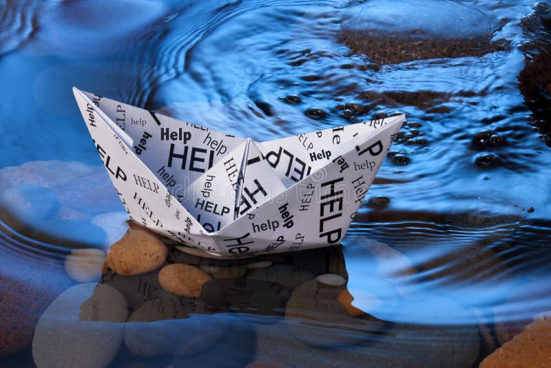 A conceptual image of a white paper boat with help written all over, floating on water rocks and waves. A conceptual image of a white paper boat with help written all over, floating on water rocks and waves