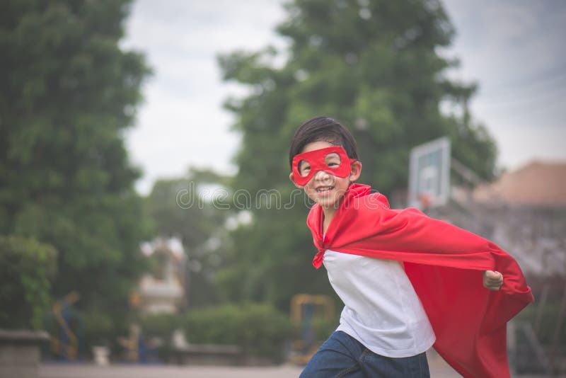 Aziatisch kind binnen in superhero` s kostuum het spelen stock foto Aziatisch kind binnen in superhero` s kostuum het spelen stock foto