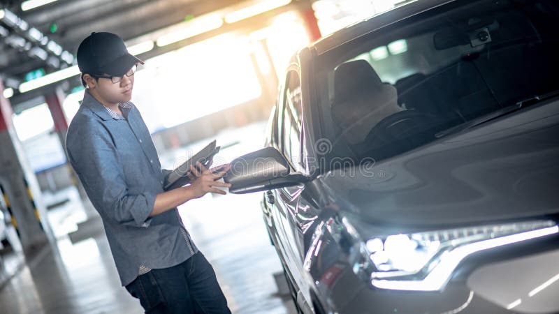 Aziatische autowerktuigkundige die de auto controleren die tablet gebruiken royalty-vrije stock foto Aziatische autowerktuigkundige die de auto controleren die tablet gebruiken royalty-vrije stock foto