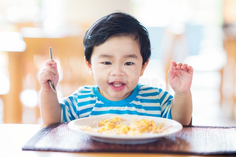 Aziatische baby die een ontbijt eten stock afbeelding Aziatische baby die een ontbijt eten stock afbeelding