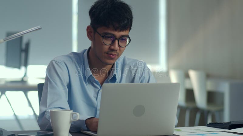 Aziatische creatieve man die op laptop werkt. jonge professionele man met computergestuurde informatica