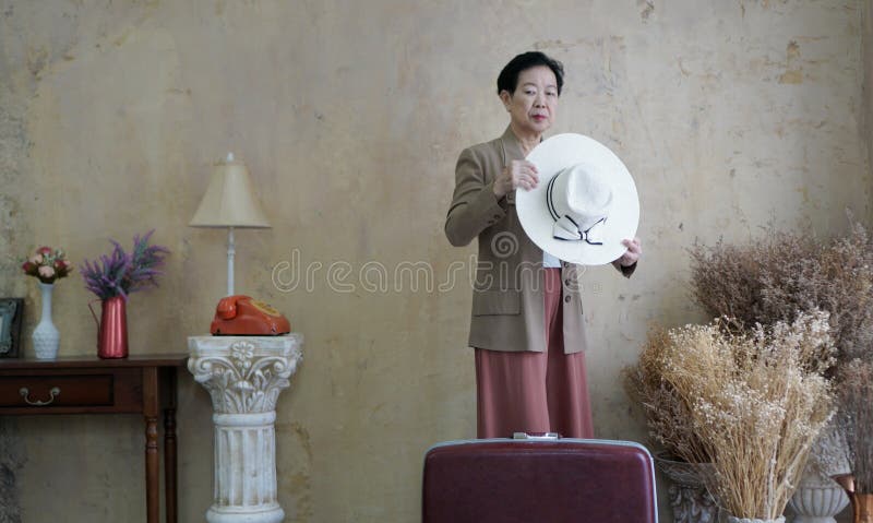 Aziatische hogere vrouwen uitstekende hoed, retro manier met reis luggag stock foto's Aziatische hogere vrouwen uitstekende hoed, retro manier met reis luggag stock foto's