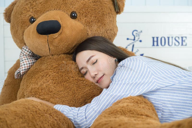 Aziatische meisjesslaap op het bed met een grote bruine teddybeer stock afbeeldingen Aziatische meisjesslaap op het bed met een grote bruine teddybeer stock afbeeldingen