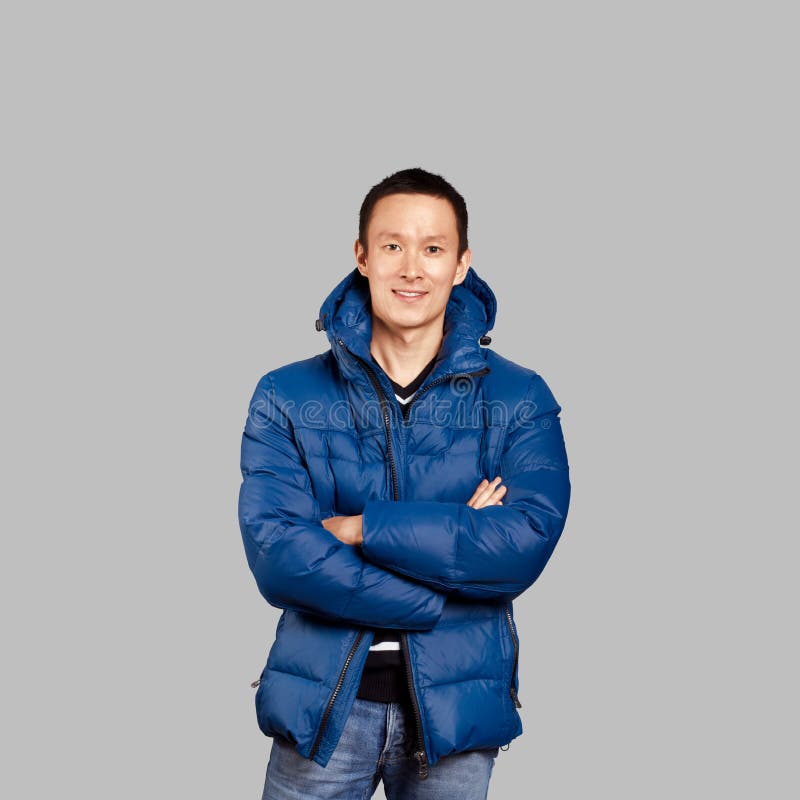 Aziatische mens in blauw beneden-opgevulde laag royalty-vrije stock foto Aziatische mens in blauw beneden-opgevulde laag royalty-vrije stock foto
