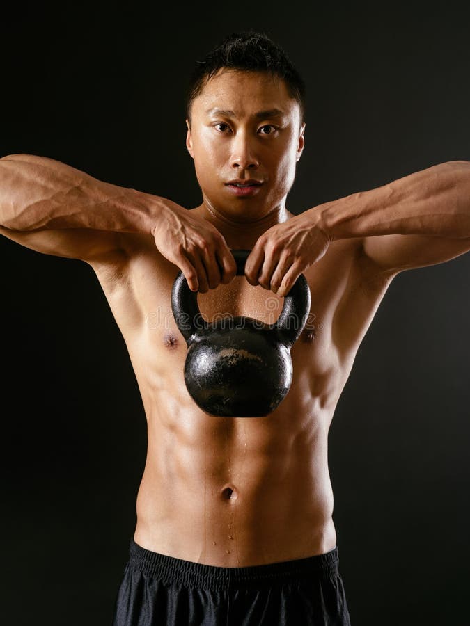 Aziatische mens die met kettlebell uitoefenen royalty-vrije stock foto Aziatische mens die met kettlebell uitoefenen royalty-vrije stock foto