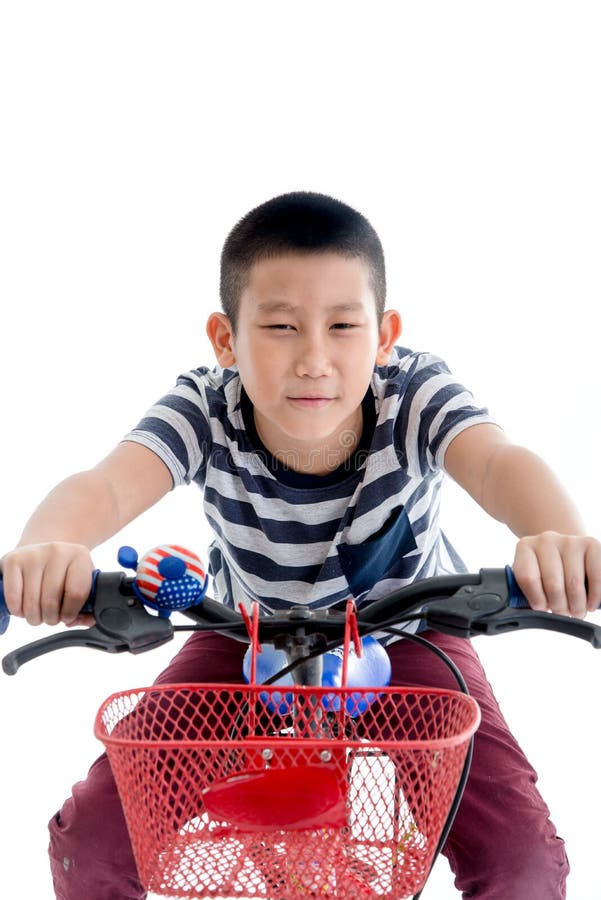 Aziatische schooljongen met rugzak die een fiets berijden stock foto Aziatische schooljongen met rugzak die een fiets berijden stock foto