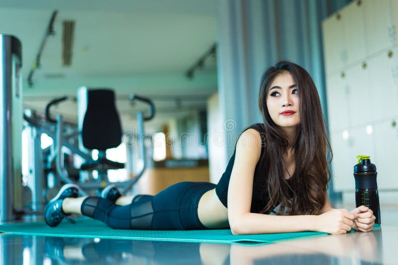 Aziatische sportvrouw die of op tredmolenmateriaal lopen lopen in F royalty-vrije stock afbeelding Aziatische sportvrouw die of op tredmolenmateriaal lopen lopen in F royalty-vrije stock afbeelding