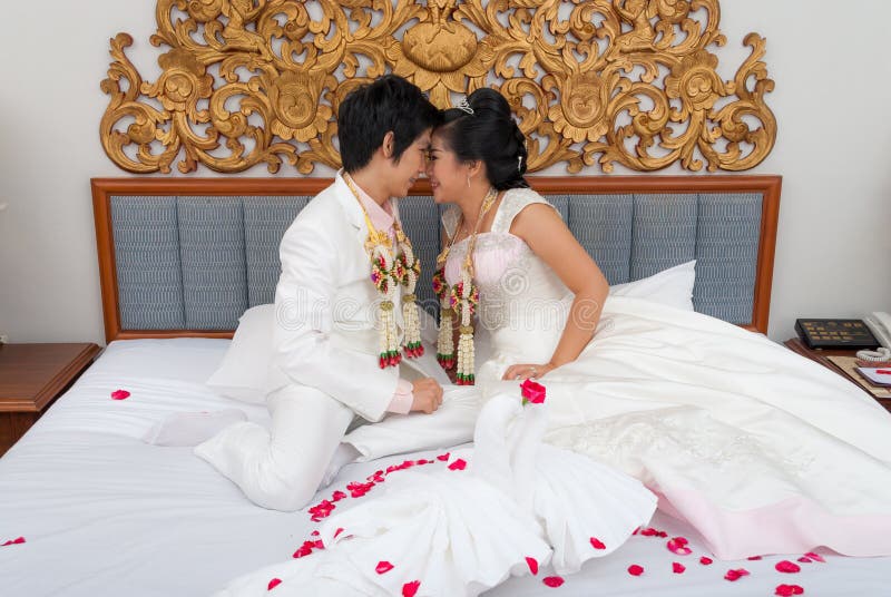 Aziatische Thaise Bruid en Bruidegom op een Bed in Huwelijksdag