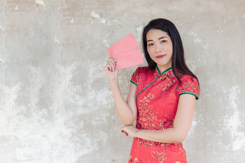 Aziatische vrouw die rode traditionele kleding dragen die rode zak met ruimte voor tekst houden stock foto Aziatische vrouw die rode traditionele kleding dragen die rode zak met ruimte voor tekst houden stock foto