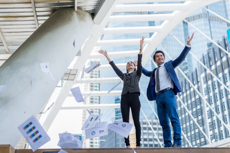 Aziatische zakenman en onderneemster die document in de lucht werpen en op twee handen aan vrolijk opheffen en gevierd voor succe royalty-vrije stock foto Aziatische zakenman en onderneemster die document in de lucht werpen en op twee handen aan vrolijk opheffen en gevierd voor succe royalty-vrije stock foto