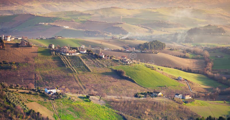 Aziende agricole e campi verdi sulle colline, Italia immagine stock libera da diritti Aziende agricole e campi verdi sulle colline, Italia immagine stock libera da diritti