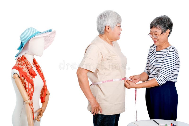 Azione anziana asiatica di manifestazione della donna del sarto della misura del corpo per l'altro cliente anziano vicino al bura immagine stock Azione anziana asiatica di manifestazione della donna del sarto della misura del corpo per l'altro cliente anziano vicino al bura immagine stock
