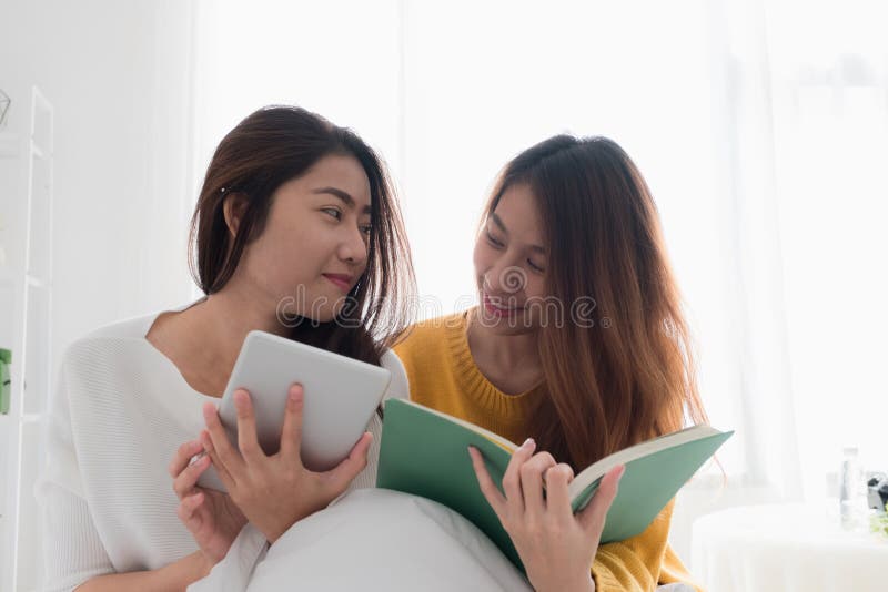 Azja lesbian lgbt pary obsiadanie na łóżkowej czytelniczej książce i use zakładce zdjęcie royalty free Azja lesbian lgbt pary obsiadanie na łóżkowej czytelniczej książce i use zakładce zdjęcie royalty free
