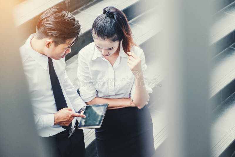 Azjatyccy ludzie biznesu spotyka cyfrową pastylkę plenerową po pracy i używa obrazy stock