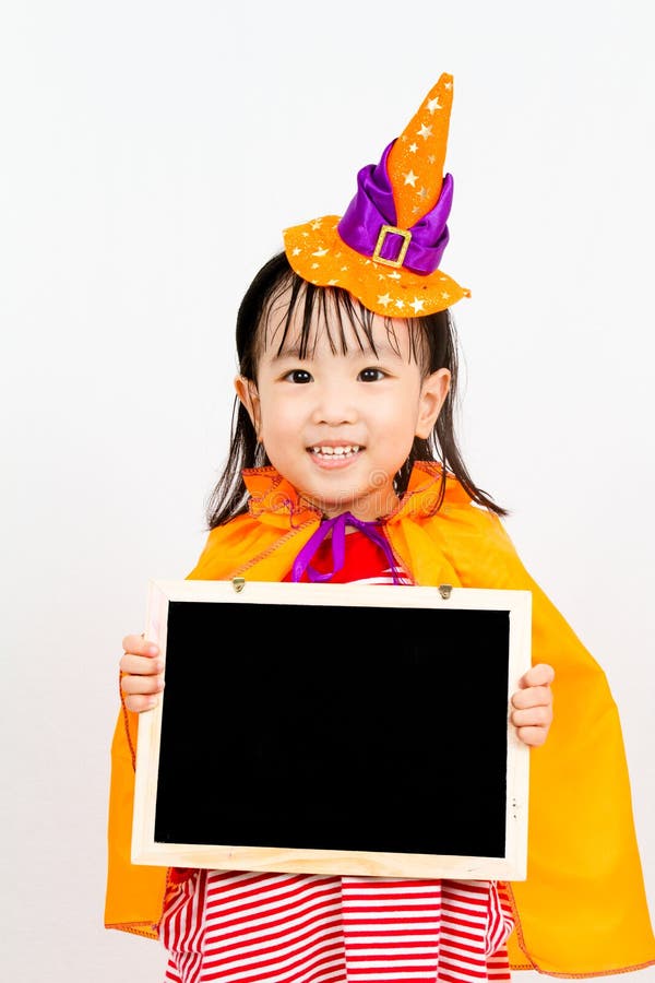 Asian Chinese Little girl celebrate Halloween holding blank black board. Asian Chinese Little girl celebrate Halloween holding blank black board.