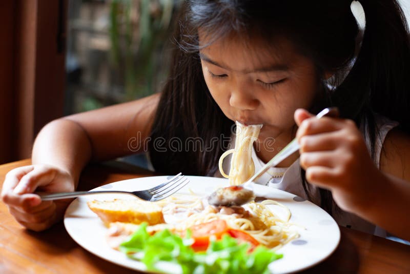 Azjatycka dziecko dziewczyna je wyśmienicie spaghetti Carbonara obrazy royalty free Azjatycka dziecko dziewczyna je wyśmienicie spaghetti Carbonara obrazy royalty free