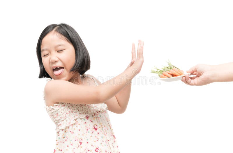 Asian child girl with expression of disgust against vegetables on white background, Refusing food concept. Asian child girl with expression of disgust against vegetables on white background, Refusing food concept