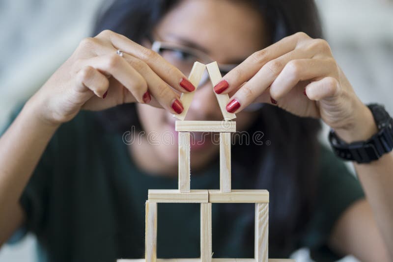 Azjatycka kobieta buduje dom drewniani bloki