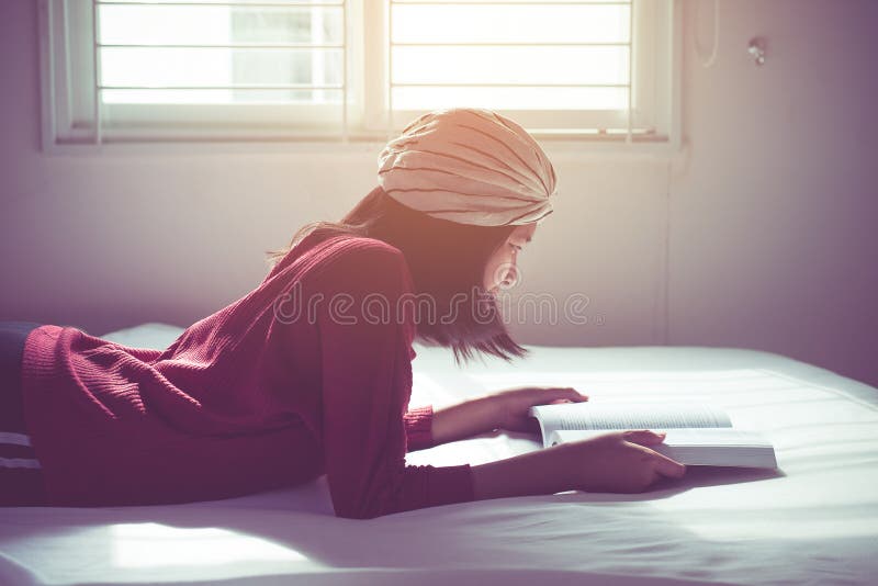 Woman reading a book feelling happy and relax on bedroom at home with sun flare. Woman reading a book feelling happy and relax on bedroom at home with sun flare