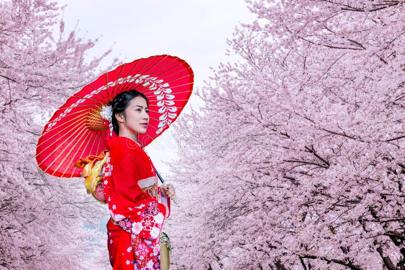 Azjatycka kobieta jest ubranym japońskiego tradycyjnego kimono i czereśniowego okwitnięcie w wiośnie, Japonia fotografia royalty free Azjatycka kobieta jest ubranym japońskiego tradycyjnego kimono i czereśniowego okwitnięcie w wiośnie, Japonia fotografia royalty free