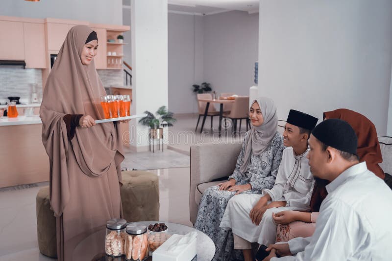 Beautiful asian muslim women served sweet drink to her family for break fasting togehter at home. Beautiful asian muslim women served sweet drink to her family for break fasting togehter at home