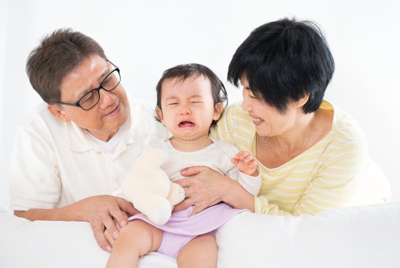 Asian family pamper crying baby girl, grandparents and grandchild indoor living lifestyle at home. Asian family pamper crying baby girl, grandparents and grandchild indoor living lifestyle at home.