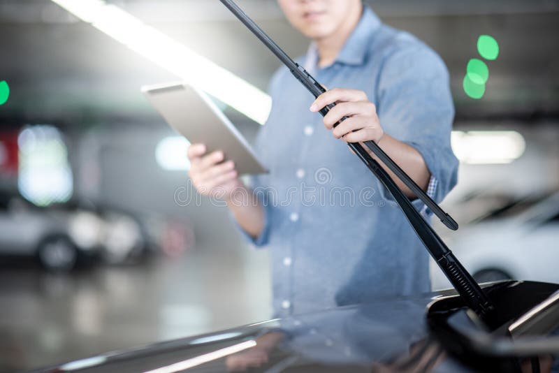 Azjatycki auto mechanik sprawdza przedniej szyby wiper zdjęcie stock Azjatycki auto mechanik sprawdza przedniej szyby wiper zdjęcie stock