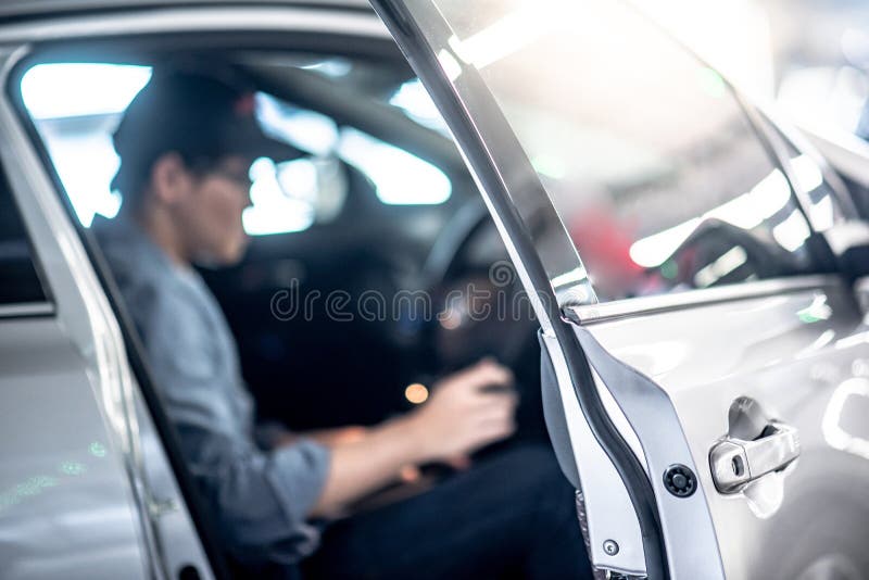 Azjatycki auto mechanika obsiadanie wśrodku samochodu obraz stock Azjatycki auto mechanika obsiadanie wśrodku samochodu obraz stock