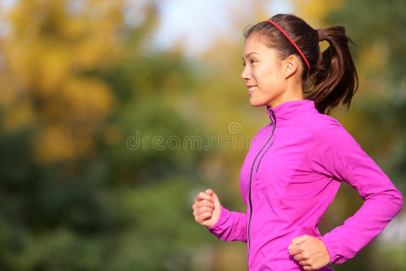 Azjatycki kobieta bieg w jesień lesie w spadku