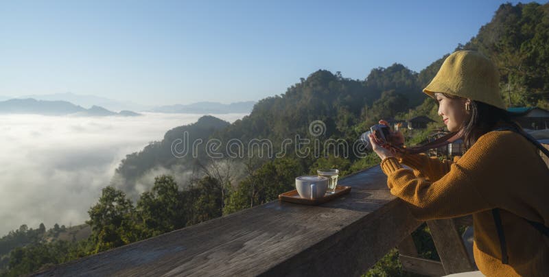 Azjatycki podróżnik z kamerą fotografują mgłę na górze w wiosce japo