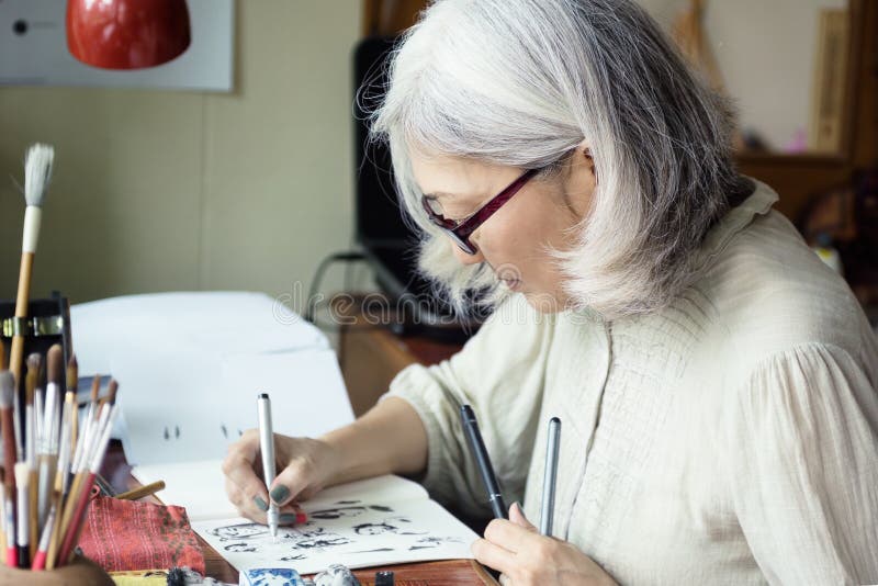 Azjatycki starszy kobieta artysty kreślić