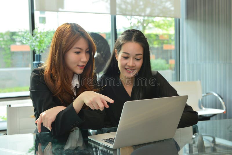 Azjatyckie biznesowe kobiety pracuje laptop i używa w pokoju konferencyjnym obraz stock Azjatyckie biznesowe kobiety pracuje laptop i używa w pokoju konferencyjnym obraz stock