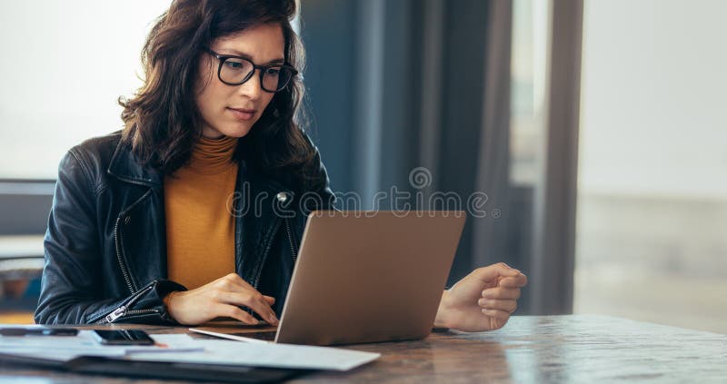 Azjatyckiej kobiety pracujący laptop przy biurem