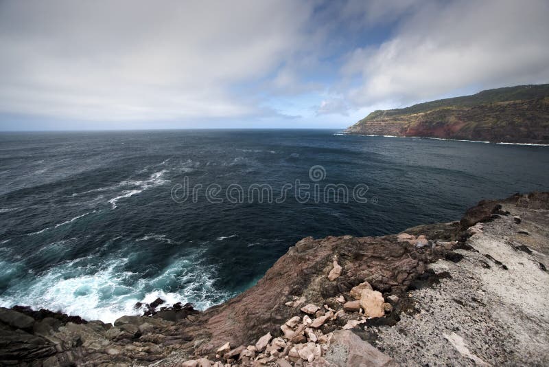 Azores shore seascape with dark clouds and rocks