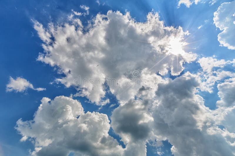 Cielo Nublado Azul Con Los Rayos Del Sol Imagen de archivo - Imagen de