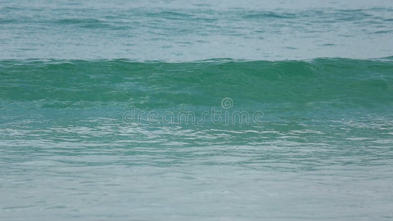 Azurblauwellen rollten auf dem Sand von Karon-Strand