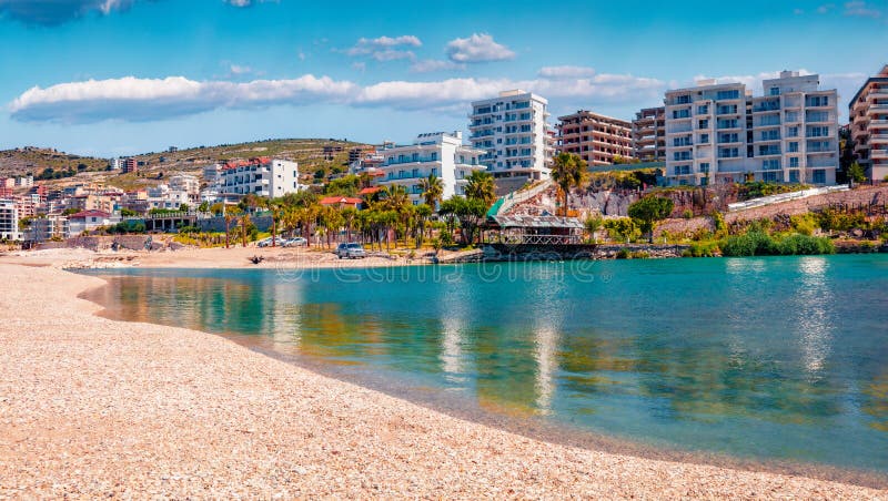 Azure river flowing in to the sea. Bright spring cityscape of Saranda port.