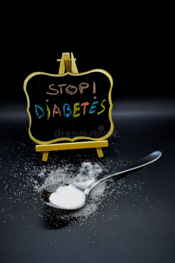 Azúcar en una cuchara con un mensaje de la diabetes de la parada en una pizarra fotografía de archivo libre de regalías Azúcar en una cuchara con un mensaje de la diabetes de la parada en una pizarra fotografía de archivo libre de regalías