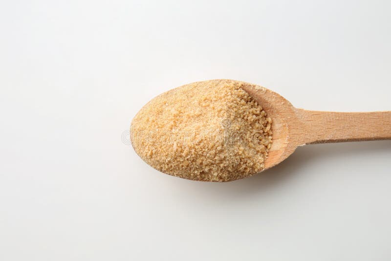 Azúcar marrón granulado en cuchara de madera en el fondo blanco imagen de archivo Azúcar marrón granulado en cuchara de madera en el fondo blanco imagen de archivo