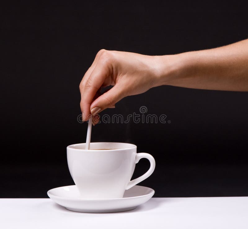 Açúcar do stir da mulher na chávena de café