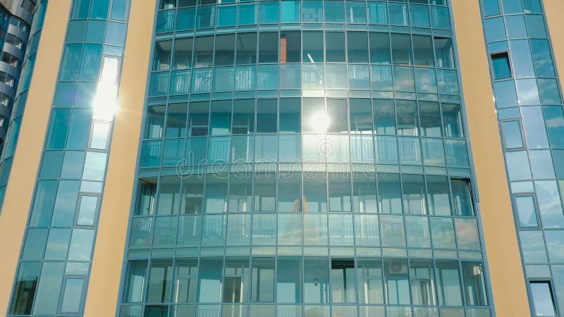 Aérien : L'extérieur des fenêtres de construction à plusieurs étages tour reflète le ciel clips vidéos
