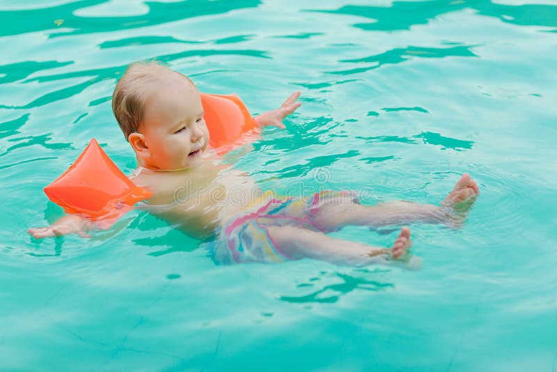 Bébé Avec Des Brassards Dans La Piscine Banque D'Images et Photos