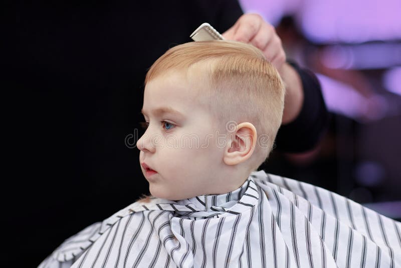 Cute Blond Baby Boy In A Barber Shop Having Haircut By Hairdresser Hands Of Stylist With Tools Image Stock Image Du Caucasien Main