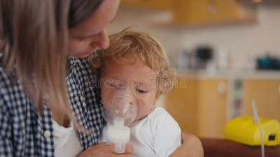 Bébé Garçon Respire Par Un Inhalateur Ou Un Nébulisateur Assis Dans Les  Bras De Sa Mère Banque De Vidéos - Vidéo du masque, allergie: 253661622