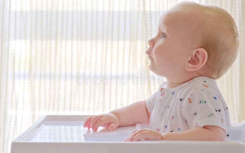 Un Bébé Mignon Est Assis Dans Une Chaise Bébé à La Maison Dans La