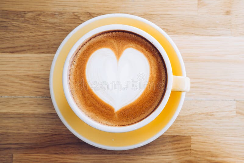 B? sta sikt av den varma cappuccinokaffekoppen p? tr? magasinet med hj? rtalattekonst p? tabellen p? kaf? -, banerformatmat och dr arkivfoto?
