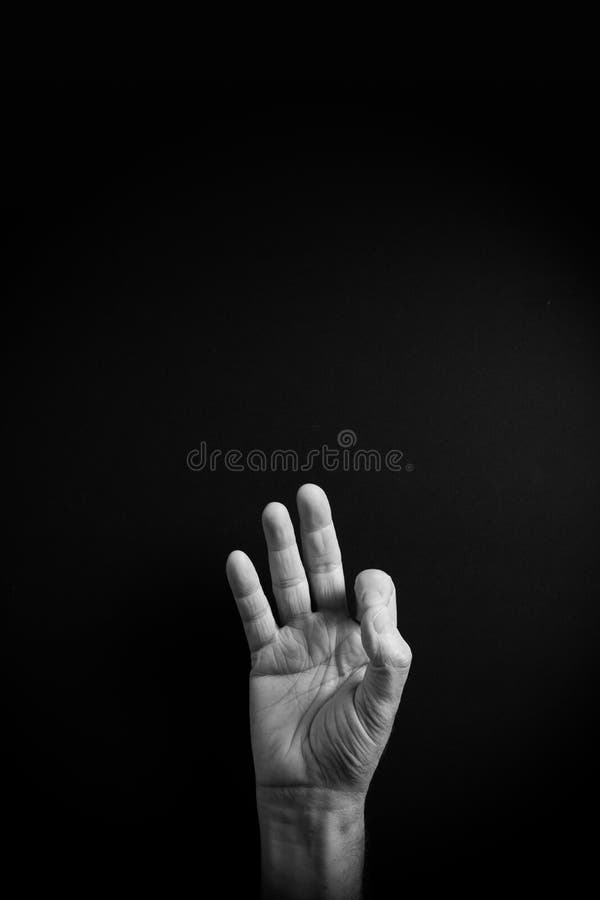 B&W image of hand demonstrating ASL sign language letter F with empty copy space royalty free stock image