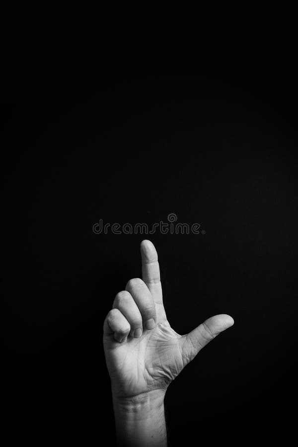 B&W image of hand demonstrating ASL sign language letter L with empty copy space stock photography